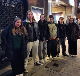 Die Studierenden warten auf den Beginn des Theaterstücks.